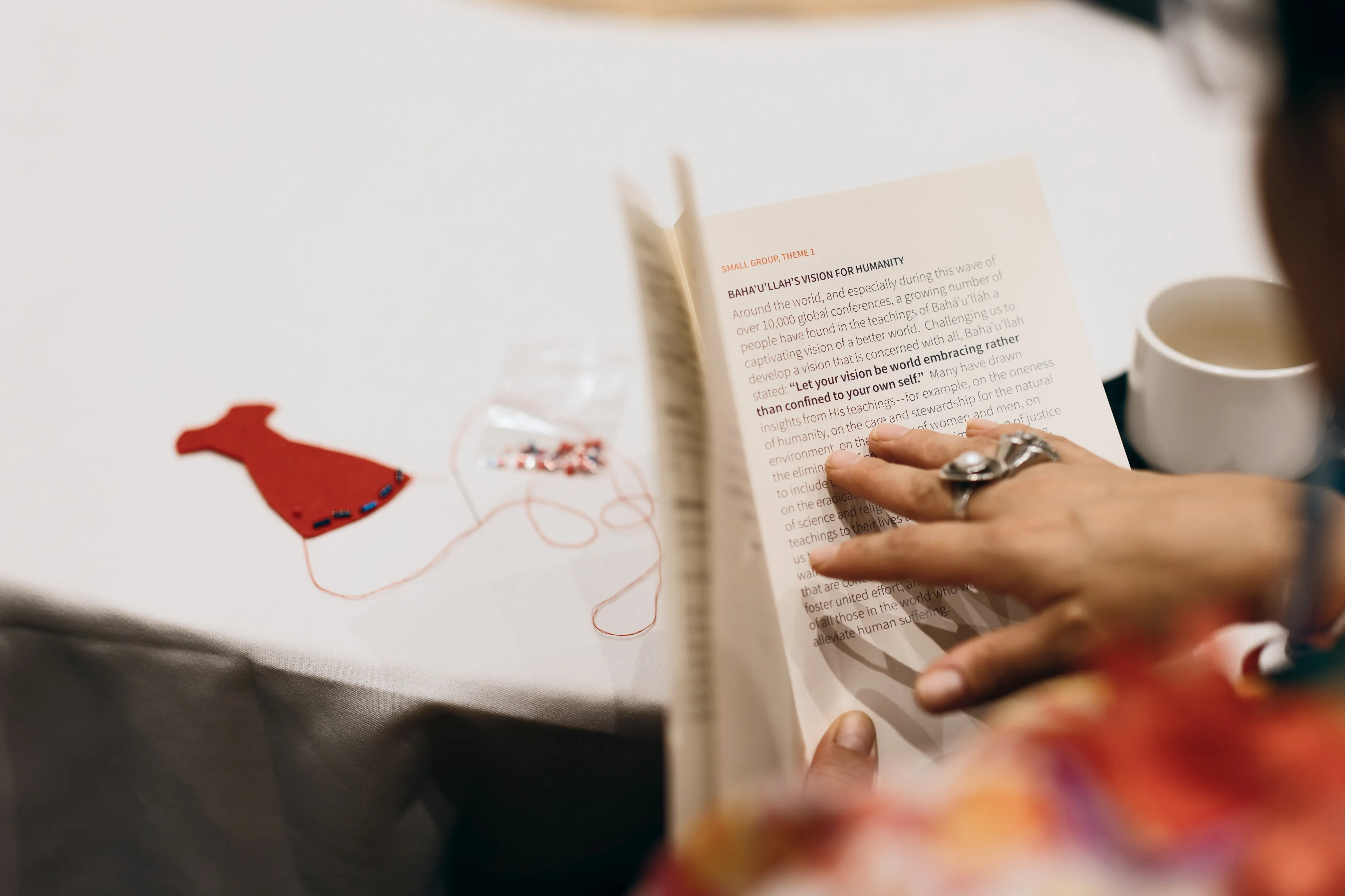 Youth pointing to a page with the quote 'Let your vision be world embracing rather than confined to your own self'